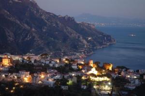 a view of a city at night with a mountain at Hotel Parsifal - Antico Convento del 1288 in Ravello