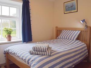 A bed or beds in a room at Coastguard Cottage 