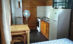 a small kitchen with a refrigerator and a table and a tableablish at Recuerdos in Atlántida