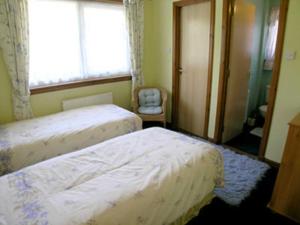 A bed or beds in a room at Distillery Croft Cottage 