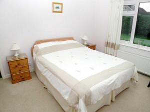 A bed or beds in a room at Tanglewinds 