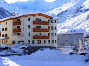 un edificio con nieve frente a una montaña en Hotel Montana, en Solda