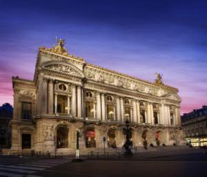 a large white building with a sunset in the background at Hôtel Royal Opéra in Paris +15 photos