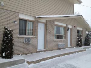 a house with two christmas trees in front of it at Milestone Motel in Collingwood