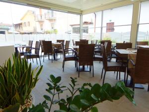 an empty restaurant with tables and chairs and windows at Hotel Clarin 14 by Dori in Peschiera del Garda