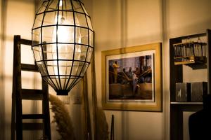 a lamp in a room with pictures on the wall at Casuzza di Girgenti con vista Valle dei Templi! in Agrigento