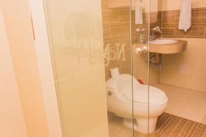 a bathroom with a toilet and a sink at Nogal Suite Hotel Pasto in Pasto