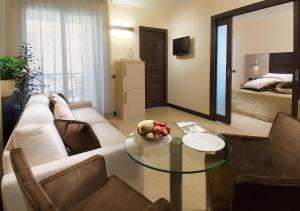 un soggiorno con divano e tavolo in vetro di Hotel Imperial a San Benedetto del Tronto