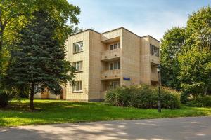 a brick building with a tree in front of it at Apart-Hotel Kurkino in Moscow