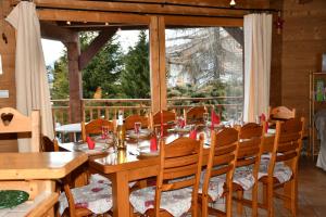een eetkamer met een tafel en stoelen en een raam bij Chalet Orlando in Les Gets