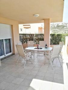 Un patio con una mesa y sillas blancas. en Apartamento Ariel, en Peñíscola