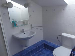 a bathroom with a white toilet and a sink at Penzion Eka in Brezno