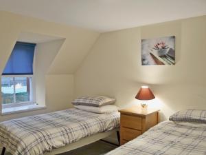 A bed or beds in a room at Millnain Cottage 