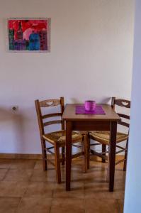 una mesa de madera con sillas y un cuenco púrpura. en Romantza, en Skala