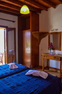 a bedroom with a blue bed with two pillows on it at Romantza in Skala
