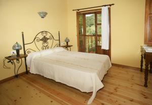 a bedroom with a large white bed in a room at Viviendas Rurales Peña Sagra in Cahecho