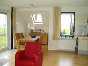a living room with a red chair and a table at Gaasthoeke in Sondel