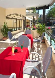 a patio with two tables and chairs with red table cloth at Hotel Villa Lieta in Rimini