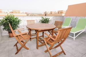 エル・メダノにあるDuplex with terrace and parking Cabezoの木製テーブルと椅子付きのパティオ
