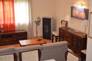 een woonkamer met een bank en een tv bij Casa do Poco in Armação de Pêra