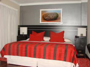 a bedroom with a red and black bed with red pillows at Zoom Apartments Hotel Boutique in Córdoba
