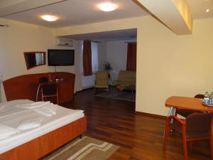 Habitación de hotel con cama, mesa y sillas en Hotel Restauracja Kinga en Katowice