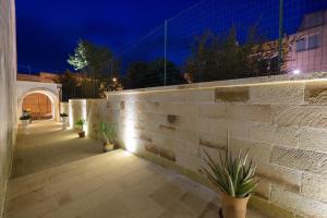 a brick wall with potted plants on a patio at night at Le Volte in Sannicola