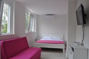 a white room with a bed and a couch at Apartments Miana in Tivat