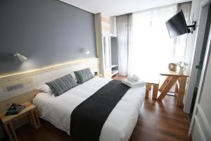 a bedroom with a large white bed in a room at Hotel Alda Centro Ponferrada in Ponferrada