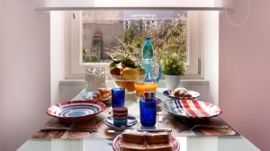 a table with plates of food and a window at Kira Guest House in Sorrento
