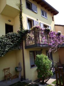 a building with a balcony with flowers on it at B&B Como Lake Cottage in Lecco