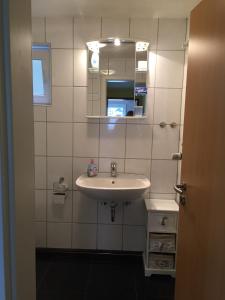 a bathroom with a sink and a mirror at FEWO Schmandin Laacher See in Wassenach
