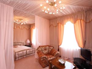 a bedroom with a bed and a chair and a chandelier at Paradise Hotel in Svitlovodsʼk