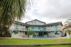 un gran edificio blanco con piscina y palmeras en Xingu Praia Hotel, en Altamira
