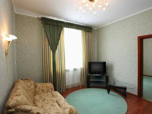 a living room with a couch and a television at Paradise Hotel in Svitlovodsʼk