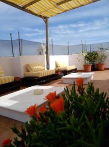 eine Terrasse mit Sofas, Tischen und Blumen in der Unterkunft Sol a Sol Hostel in Lagos