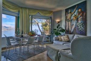 a living room with a couch and a table with chairs at Luxury Apartment and Charm Sea View Isola Bella in Taormina