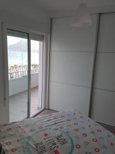 a bedroom with a bed with a view of the ocean at BlancMar Apartament in Calpe