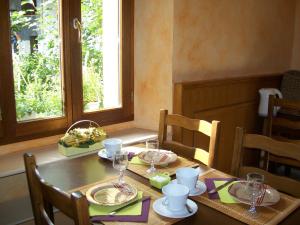 a dining room table with plates and glasses on it at Hôtel de la Mairie in LʼArgentière-la-Bessée