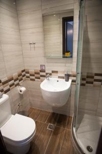 a bathroom with a sink and a toilet and a shower at Galazio Limani - Rooms to let in Moúdhros