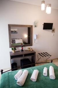 a room with a bed with a desk and a mirror at Galazio Limani - Rooms to let in Moúdhros