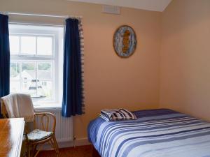 
A bed or beds in a room at Coastguard Cottage
