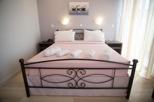 a bedroom with a pink bed with towels on it at Galazio Limani - Rooms to let in Moúdhros