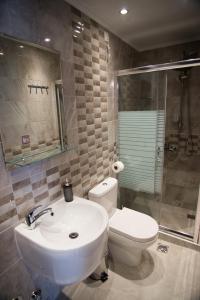 a bathroom with a sink and a toilet and a shower at Galazio Limani - Rooms to let in Moúdhros