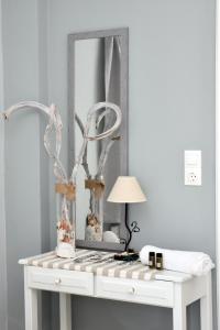 a white console table with a mirror and a lamp at Ammos Apartments in Ierápetra