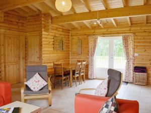 a living room with a table in a log cabin at Quail Lodge - W44304 in Burn