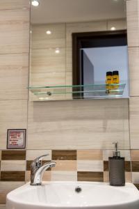 a bathroom with a sink and a mirror and a sink at Galazio Limani - Rooms to let in Moúdhros