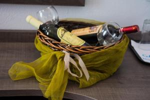 a basket of wine bottles and glasses on a table at Galazio Limani - Rooms to let in Moúdhros
