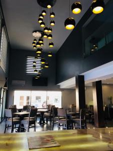 a dining room with tables and chairs and lights at Hotel Plaza Catedral in Gómez Palacio