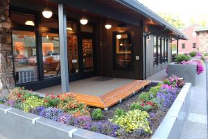 un edificio con un banco delante de él con flores en Timbers Inn en Eugene